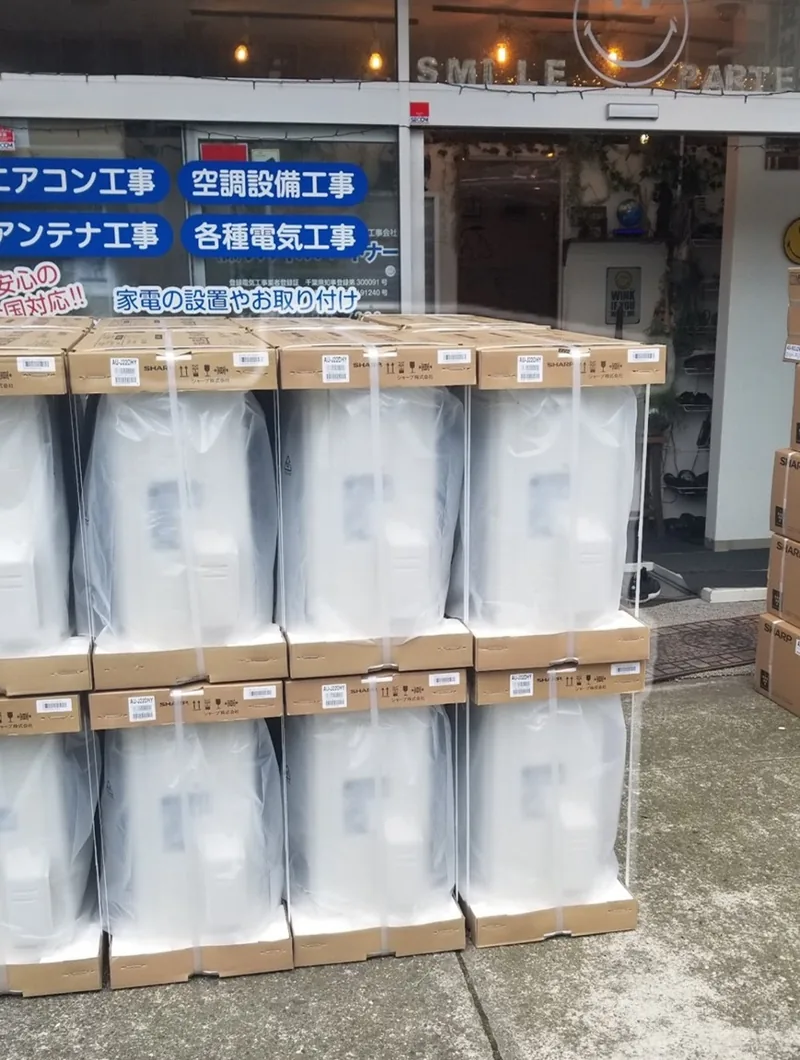 一括工事に向けて自社倉庫前に積み上げられた大量のエアコン